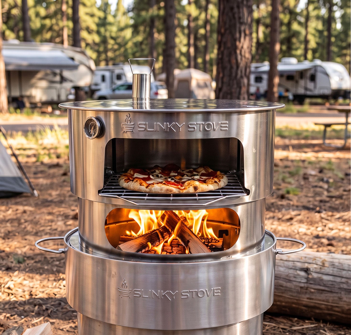 Slinky Stove pizza oven attachment mounted on the fire pit, cooking a pizza over a wood fire at an RV campsite.