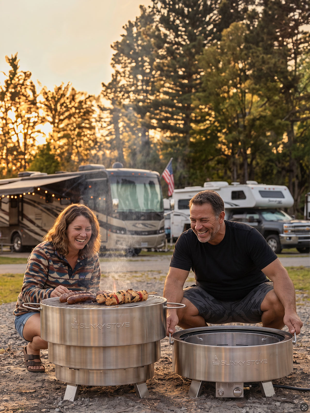 Couple grilling on a Slinky Stove fire pit at an RV campsite, with a second fire pit at its low expansion level.